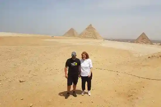 A romantic couple hugging front of the Great Pyramids.