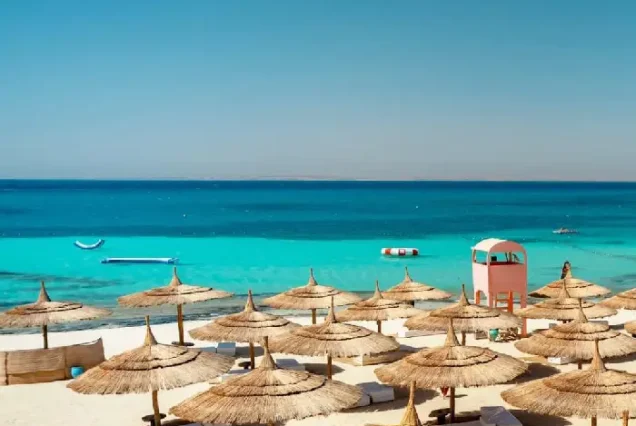 Shaded beach umbrellas and sunbeds at Paradise Island Hurghada.