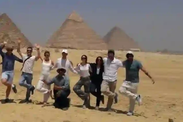 Small group of happy tourists at the Great Pyramid of Khufu.
