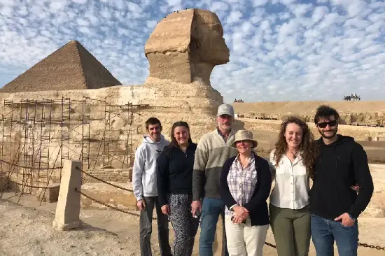Gruppe von Touristen vor der Großen Sphinx und den Pyramiden von Gizeh.